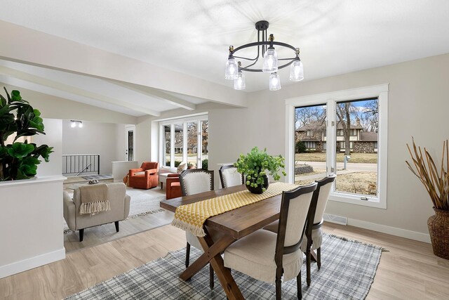 dining area featuring light wood-type flooring, a healthy amount of sunlight, baseboards, and visible vents