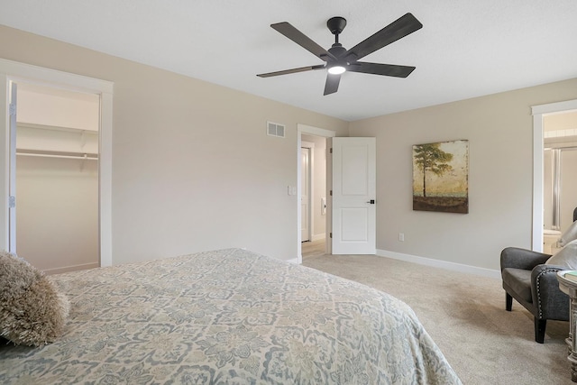 carpeted bedroom featuring ensuite bath, baseboards, a ceiling fan, and visible vents
