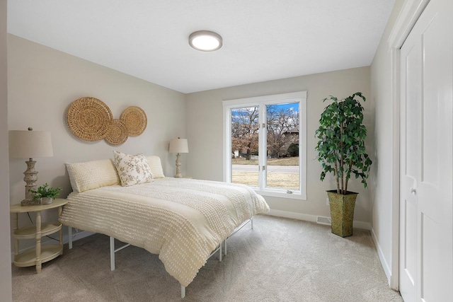 bedroom with visible vents, baseboards, and light colored carpet
