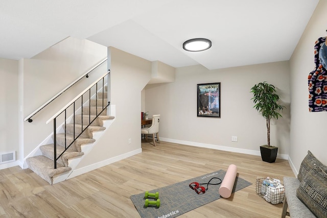 workout room with baseboards, wood finished floors, and visible vents