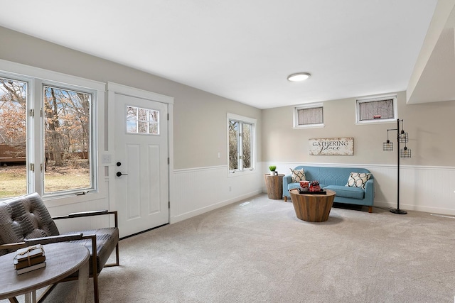 interior space with carpet flooring and a wainscoted wall