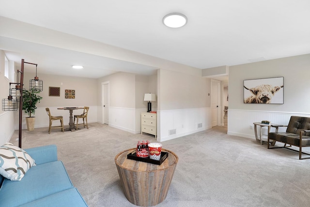living room with wainscoting, light carpet, and visible vents
