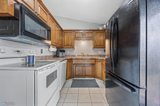 kitchen with black appliances, vaulted ceiling, brown cabinets, light tile patterned floors, and a sink