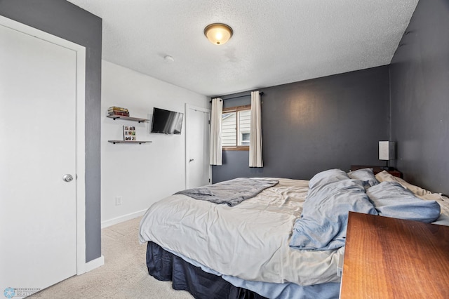 bedroom featuring carpet flooring, a textured ceiling, and baseboards