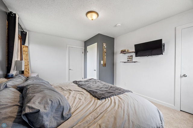 bedroom featuring carpet, baseboards, and a textured ceiling