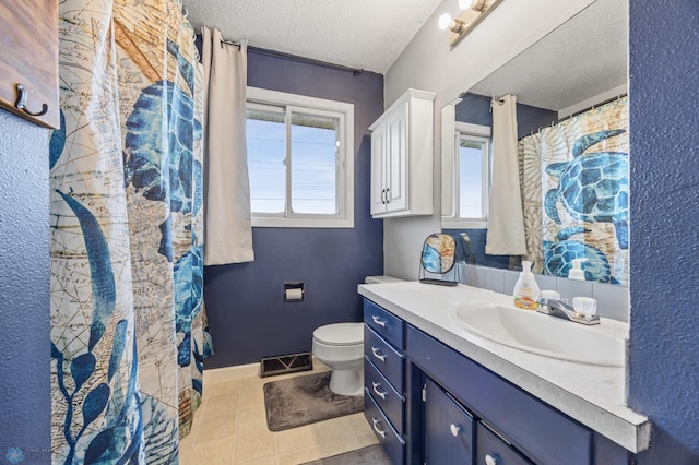 full bathroom featuring a textured ceiling, toilet, vanity, and tile patterned flooring