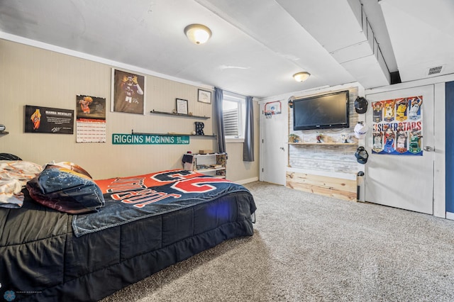 carpeted bedroom featuring wood walls