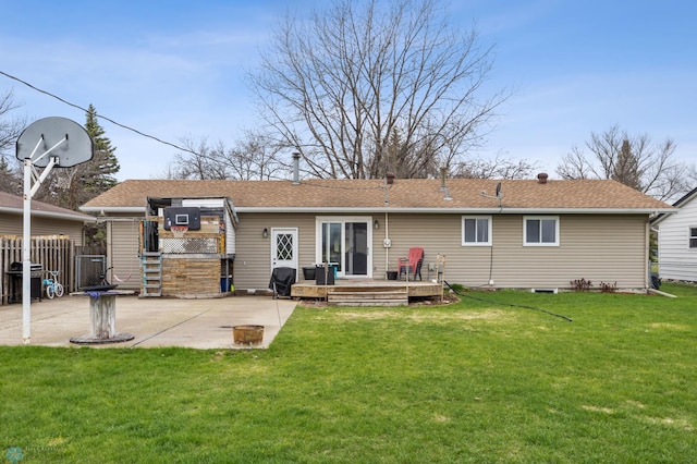 rear view of property featuring a wooden deck, a patio area, and roof with shingles
