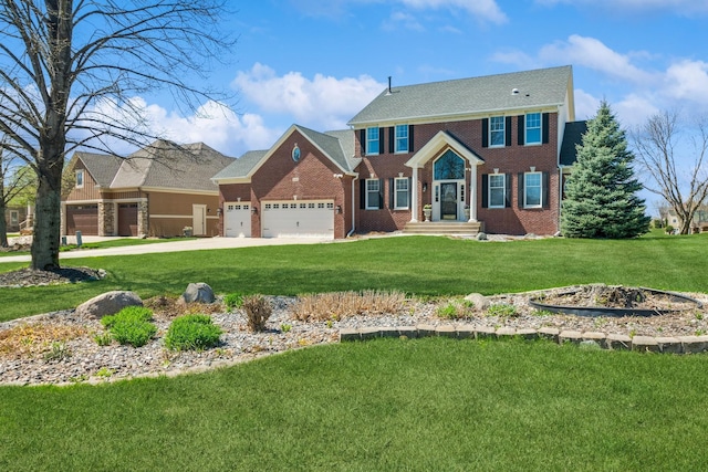 colonial inspired home with brick siding, an attached garage, driveway, and a front lawn