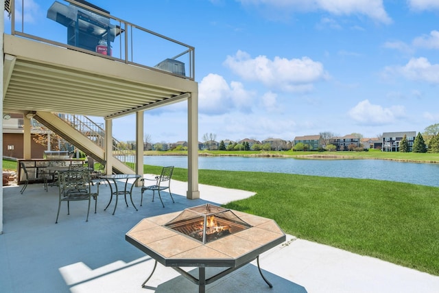 view of patio / terrace featuring a water view, a fire pit, stairs, and outdoor dining space