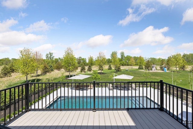 7450 73rd Ct N, Grant, MN 55082 - deck featuring a lawn, a playground, a patio, and view of scattered trees