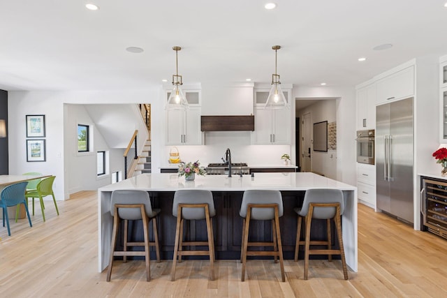 7450 73rd Ct N, Grant, MN 55082 - kitchen featuring appliances with stainless steel finishes, light countertops, recessed lighting, white cabinets, and a center island with sink