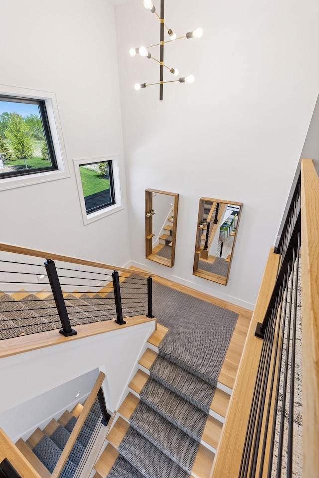 7450 73rd Ct N, Grant, MN 55082 - staircase featuring wood finished floors, a chandelier, a high ceiling, and baseboards