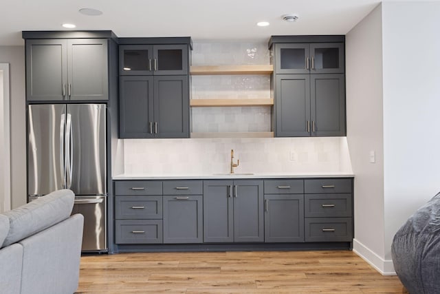7450 73rd Ct N, Grant, MN 55082 - kitchen with freestanding refrigerator, a sink, open floor plan, gray cabinetry, and light wood-style flooring