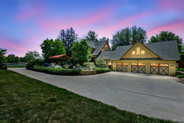 3375 Stark Rd NE, Cambridge Twp, MN 55008 - view of front of home featuring concrete driveway, a garage, stucco siding, roof with shingles, and a yard