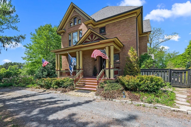 3375 Stark Rd NE, Cambridge Twp, MN 55008 - victorian-style house featuring brick siding, a porch, and a shingled roof