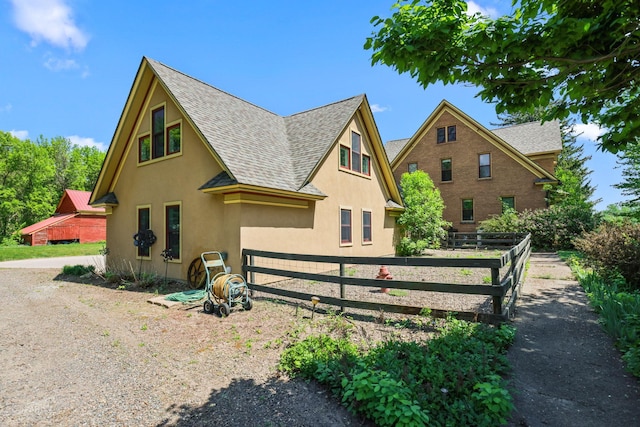 3375 Stark Rd NE, Cambridge Twp, MN 55008 - view of side of home featuring roof with shingles and stucco siding