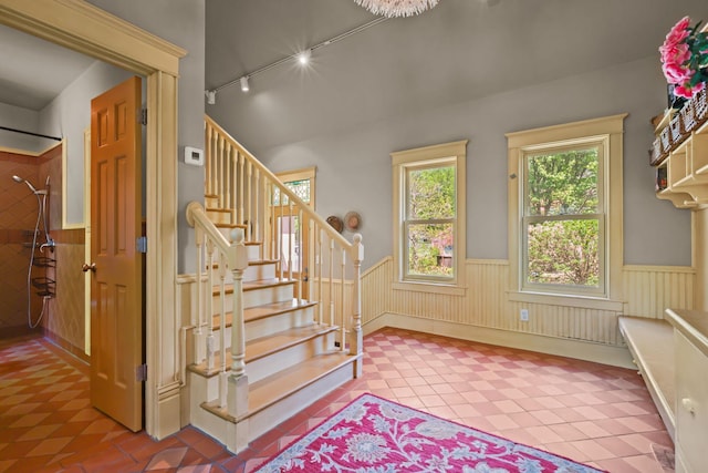 3375 Stark Rd NE, Cambridge Twp, MN 55008 - stairs with track lighting, a wainscoted wall, and tile patterned floors