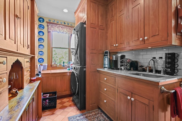 3375 Stark Rd NE, Cambridge Twp, MN 55008 - kitchen with stacked washer / dryer, brown cabinetry, light countertops, and decorative backsplash