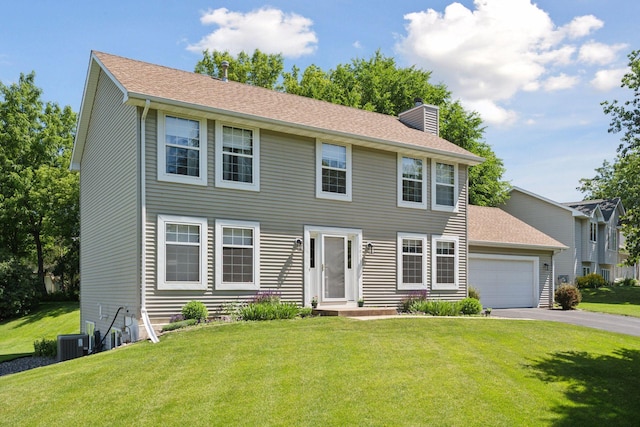 colonial inspired home featuring aphalt driveway, a chimney, central AC unit, a front lawn, and an attached garage