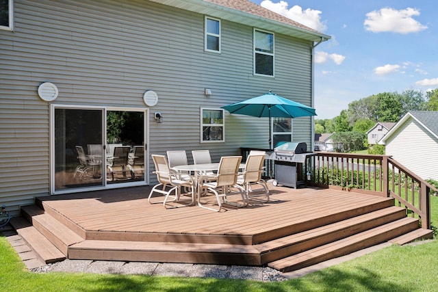 wooden terrace with outdoor dining space and grilling area