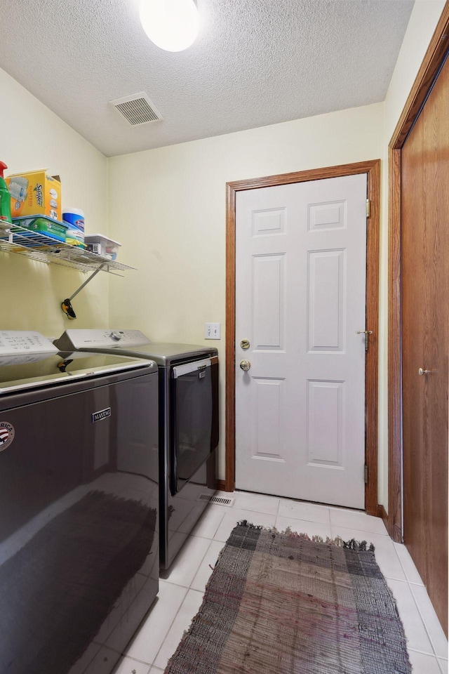 laundry area with visible vents, laundry area, a textured ceiling, and washer and dryer