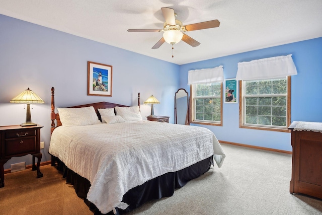 carpeted bedroom featuring baseboards and ceiling fan