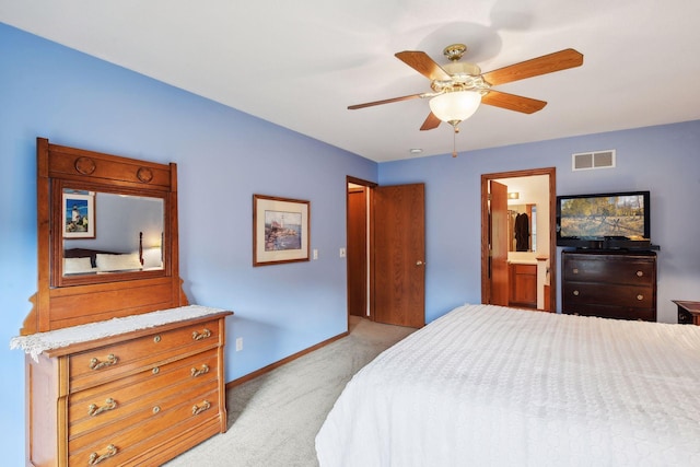 bedroom with ceiling fan, visible vents, baseboards, ensuite bathroom, and light carpet