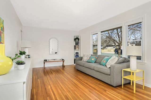 living room featuring baseboards and light wood-type flooring