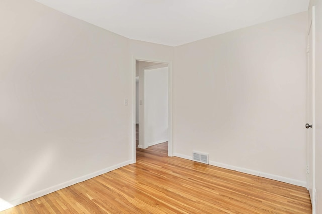 unfurnished room with baseboards, visible vents, and light wood-type flooring