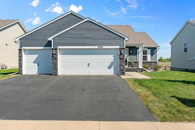8506 Titanium Cir, Woodbury, MN 55129 - view of front of house with stone siding, asphalt driveway, a front yard, a garage, and roof with shingles