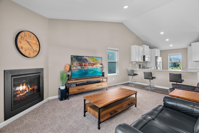 8506 Titanium Cir, Woodbury, MN 55129 - living room featuring vaulted ceiling, recessed lighting, a glass covered fireplace, and baseboards