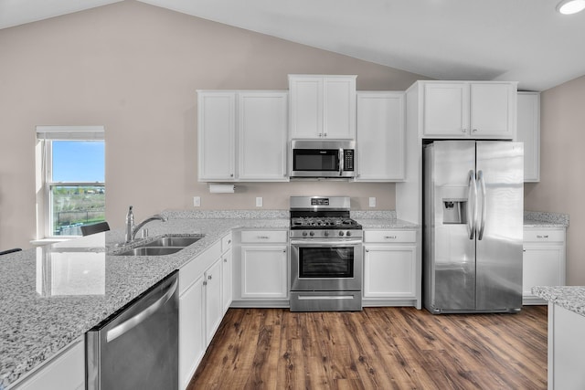 8506 Titanium Cir, Woodbury, MN 55129 - kitchen featuring appliances with stainless steel finishes, a sink, vaulted ceiling, dark wood-style flooring, and white cabinets