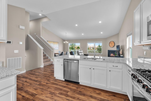 8506 Titanium Cir, Woodbury, MN 55129 - kitchen featuring stainless steel appliances, a sink, vaulted ceiling, a peninsula, and white cabinetry