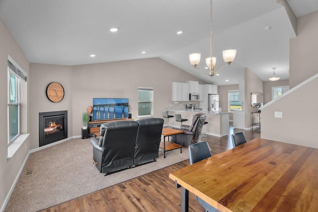 8506 Titanium Cir, Woodbury, MN 55129 - living room featuring a chandelier, lofted ceiling, wood finished floors, baseboards, and recessed lighting