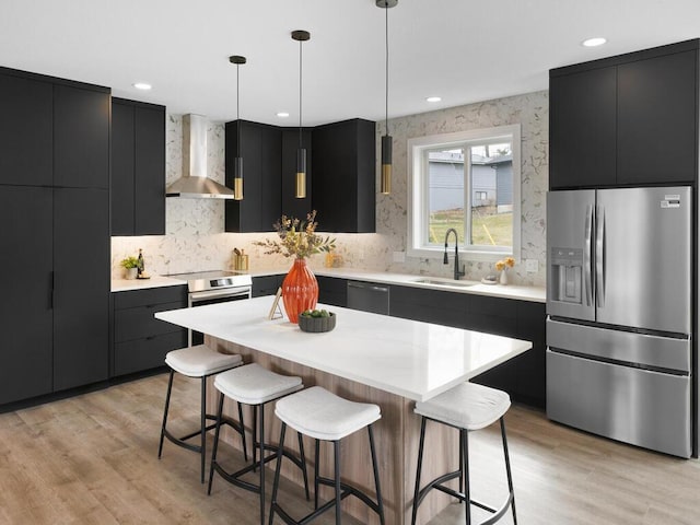 14913 Oakwood Dr, Burnsville, MN 55306 - kitchen with stainless steel appliances, dark cabinets, a sink, wall chimney exhaust hood, and a kitchen bar