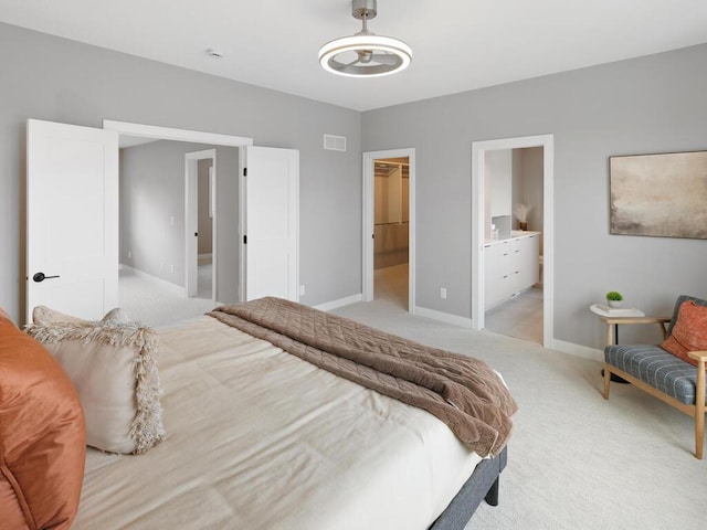 14913 Oakwood Dr, Burnsville, MN 55306 - bedroom featuring a walk in closet, light carpet, visible vents, and baseboards