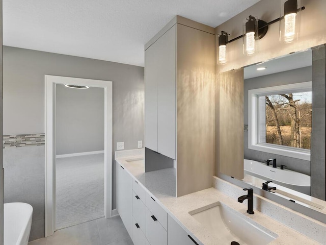 14913 Oakwood Dr, Burnsville, MN 55306 - bathroom with a freestanding bath, double vanity, tile patterned flooring, and a sink