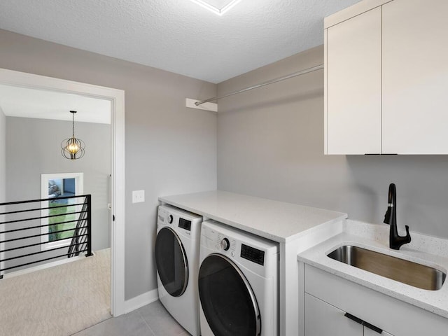 14913 Oakwood Dr, Burnsville, MN 55306 - clothes washing area featuring a sink, a textured ceiling, light tile patterned flooring, cabinet space, and washing machine and dryer