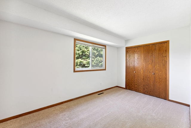 unfurnished bedroom featuring carpet, baseboards, and a closet