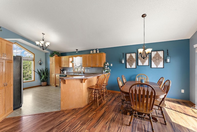 1106 Maplewood Ave SW, Isanti, MN 55040 - dining space with a chandelier, wood finished floors, and a textured ceiling