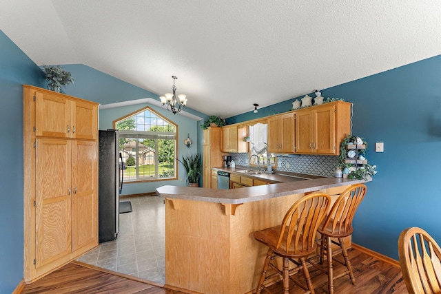 1106 Maplewood Ave SW, Isanti, MN 55040 - kitchen with vaulted ceiling, dishwasher, freestanding refrigerator, a chandelier, and a peninsula