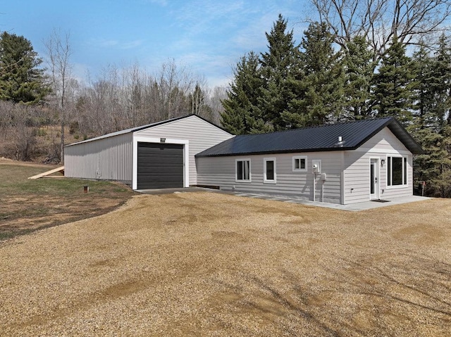 detached garage featuring dirt driveway