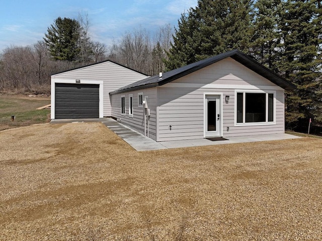 ranch-style house featuring driveway, an outbuilding, and a garage