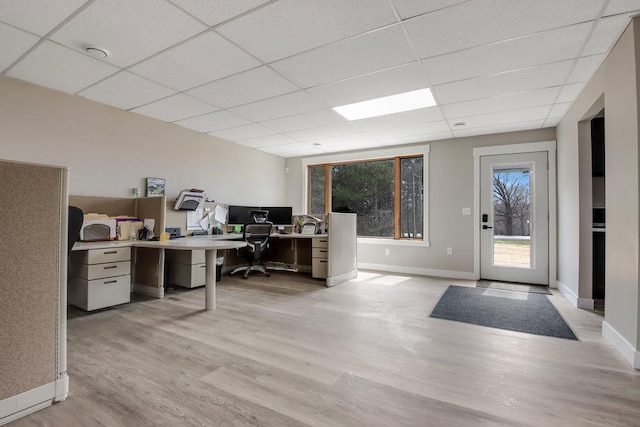 home office featuring baseboards, a paneled ceiling, and light wood-style flooring