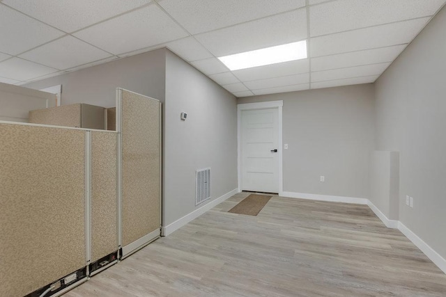 empty room featuring visible vents, wood finished floors, and a drop ceiling