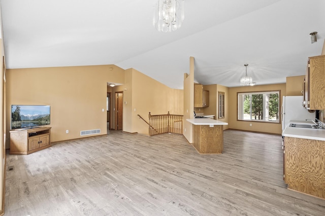 17813 224th Ave NW, Big Lake, MN 55309 - kitchen featuring a chandelier, open floor plan, a sink, light wood-style flooring, and lofted ceiling