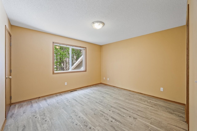 17813 224th Ave NW, Big Lake, MN 55309 - spare room featuring light wood-style floors, a textured ceiling, and baseboards