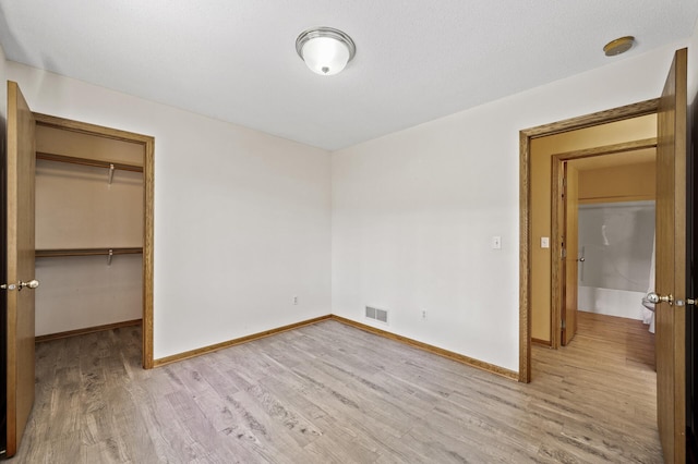 17813 224th Ave NW, Big Lake, MN 55309 - unfurnished bedroom with light wood-style floors, baseboards, a closet, and a spacious closet