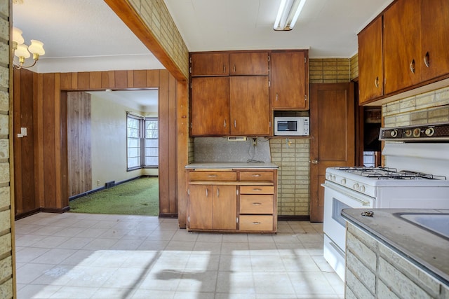 123 Thomas Hill Rd, Jackson, MN 56143 - kitchen featuring brown cabinetry, decorative backsplash, white appliances, light countertops, and baseboards